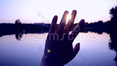 黑色的手的轮廓在空中移动，通过手指穿过阳光